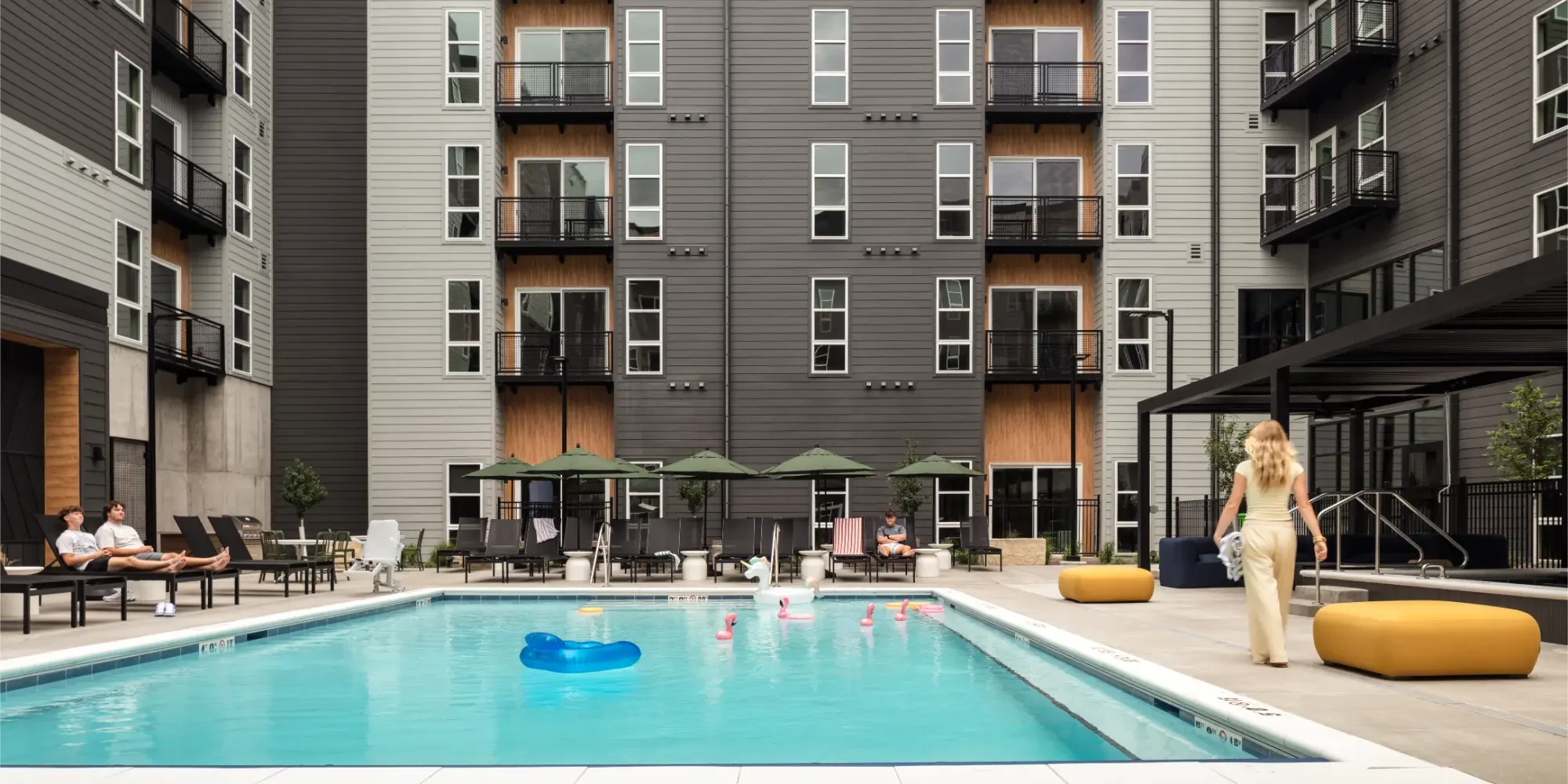View of the outdoor pool and lounge area at Replay Iowa City's luxury student apartments near the University of Iowa campus